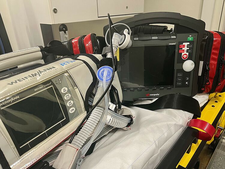RD_Geräte_RTW__09_2025 Beatmungsgerät und Defibrillator liegend auf der Patiententrage
